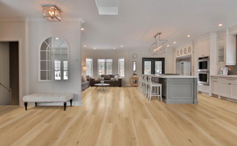 warm toned wood look flooring in kitchen with grey cabinets and white chairs.